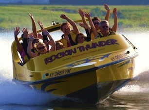 Riders with arms up in jet boat